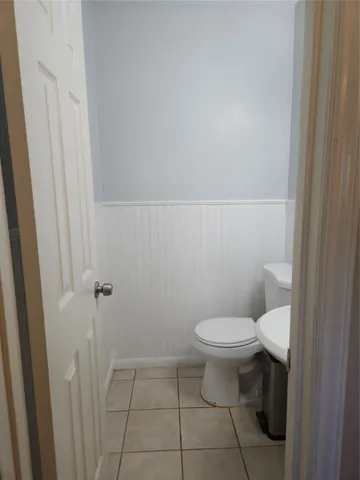 a white toilet sitting next to a white cabinet