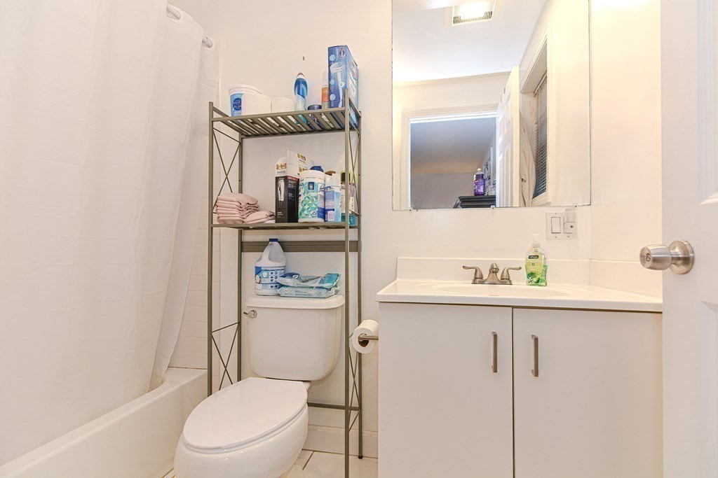 89 Broad Street, Unit 1 Lynn, MA 01902 - Photo 16 of 23 a bathroom with a toilet a sink and mirror