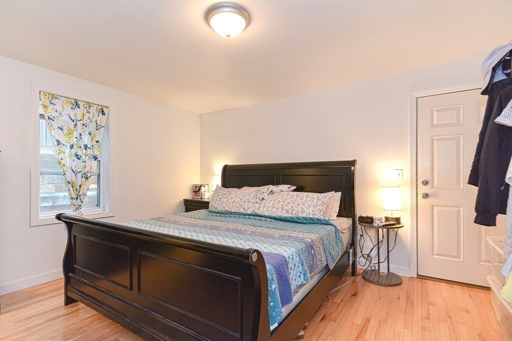 89 Broad Street, Unit 1 Lynn, MA 01902 - Photo 17 of 23 a bedroom with a bed and wooden floor