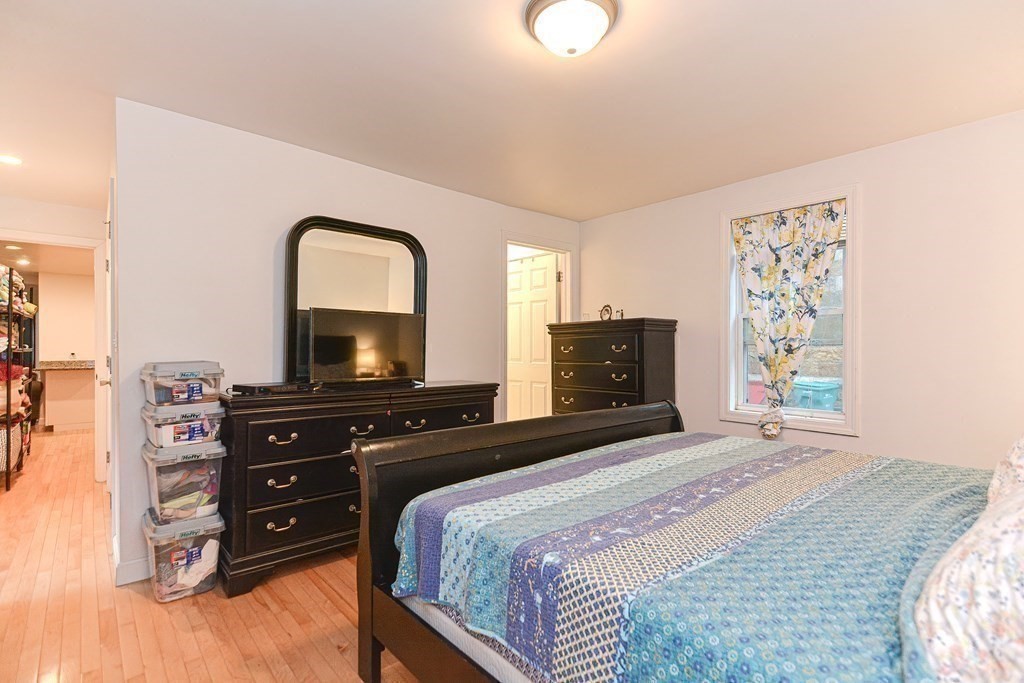 89 Broad Street, Unit 1 Lynn, MA 01902 - Photo 18 of 23 a bedroom with a bed and a flat screen tv