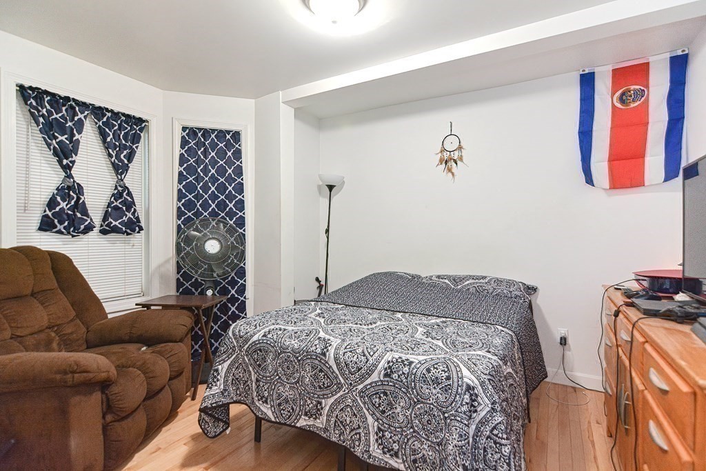 89 Broad Street, Unit 1 Lynn, MA 01902 - Photo 19 of 23 a living room with a couch and a painting on the wall