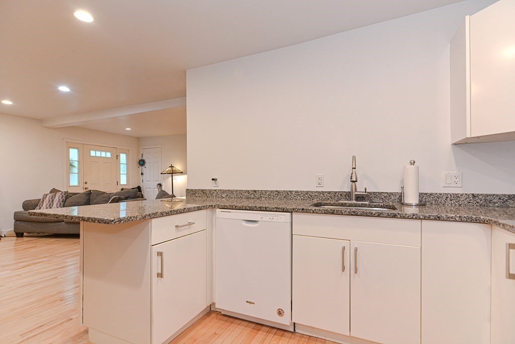 89 Broad Street, Unit 1 Lynn, MA 01902 - Photo 5 of 23 a kitchen with granite countertop a sink and cabinets