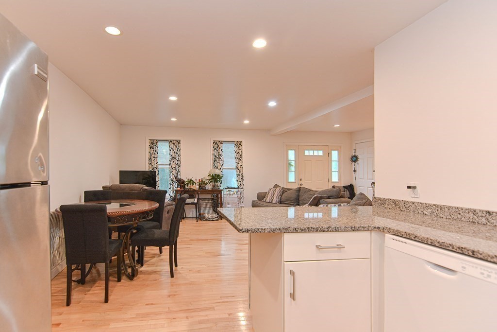89 Broad Street, Unit 1 Lynn, MA 01902 - Photo 7 of 23 a kitchen with granite countertop sink and cabinets