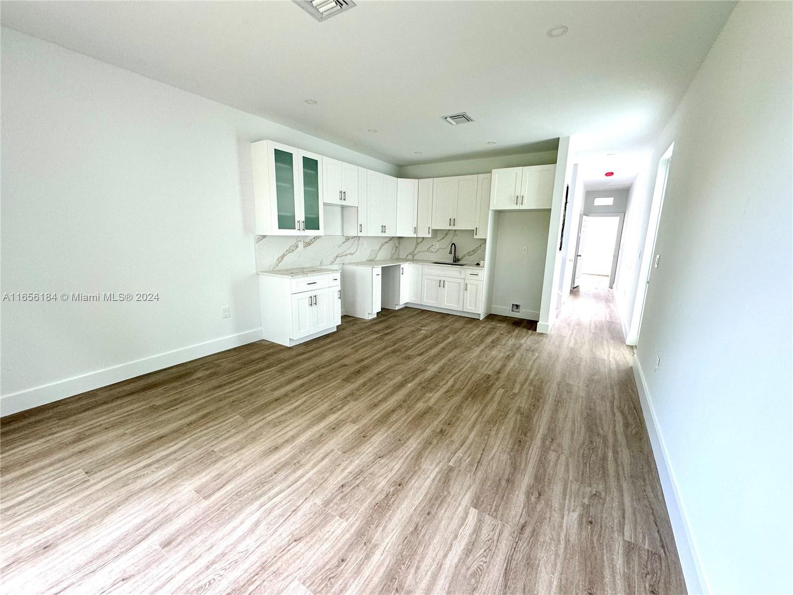 2933 Northwest 57th Street, Unit 2933 Miami, FL 33142 - Photo 1 of 14 a view of a kitchen with wooden floor