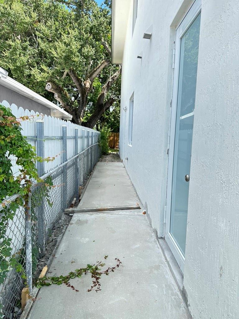 2933 Northwest 57th Street, Unit 2933 Miami, FL 33142 - Photo 12 of 14 a view of a pathway of a house with wooden fence