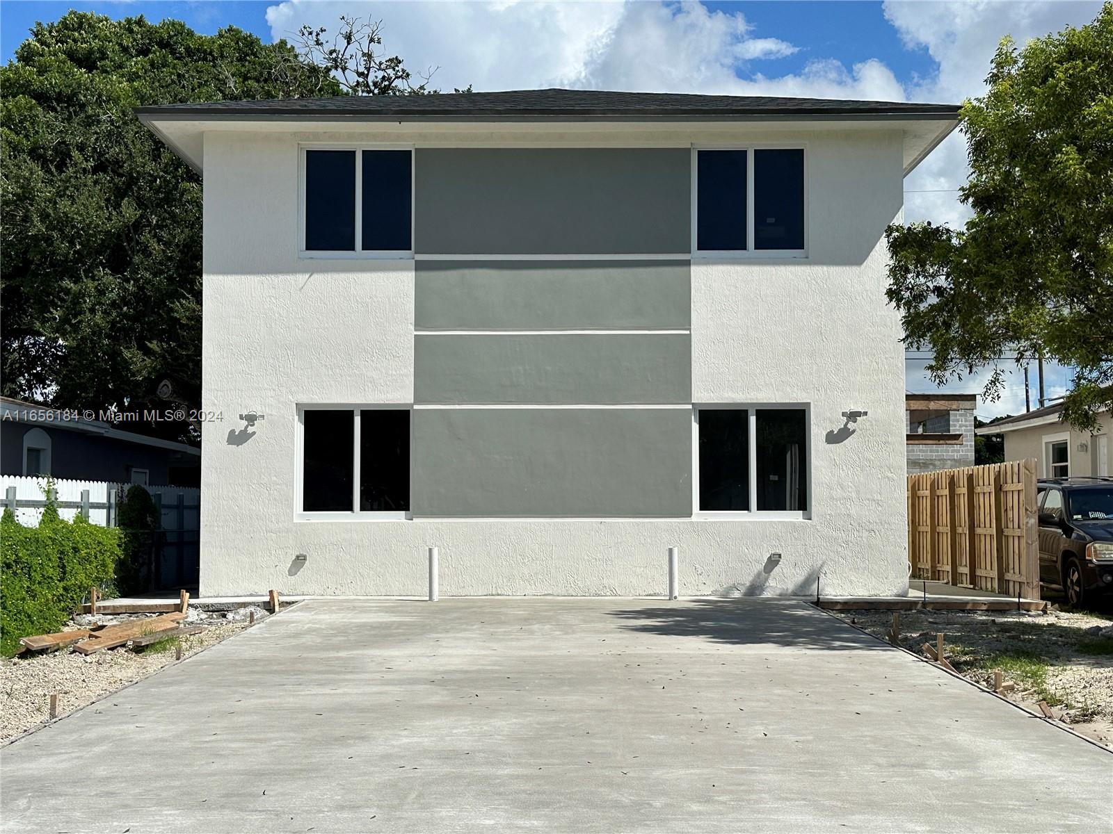 2933 Northwest 57th Street, Unit 2933 Miami, FL 33142 - Photo 13 of 14 a front view of a house with a yard and garage