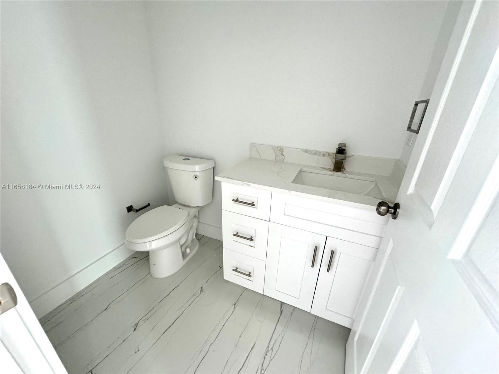 2933 Northwest 57th Street, Unit 2933 Miami, FL 33142 - Photo 3 of 14 a bathroom with a sink a toilet and a tub