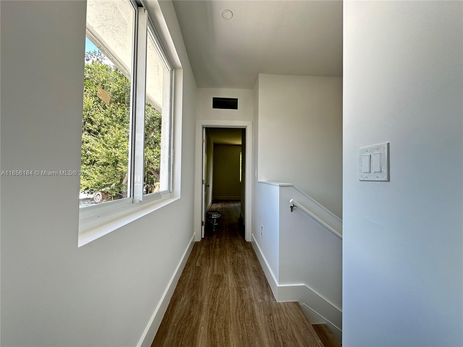 2933 Northwest 57th Street, Unit 2933 Miami, FL 33142 - Photo 7 of 14 a view of a hallway with wooden floor and staircase