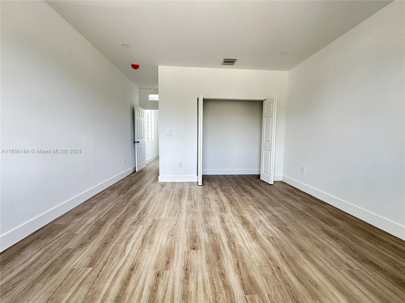 2933 Northwest 57th Street, Unit 2933 Miami, FL 33142 - Photo 8 of 14 a view of a room with wooden floor and white walls