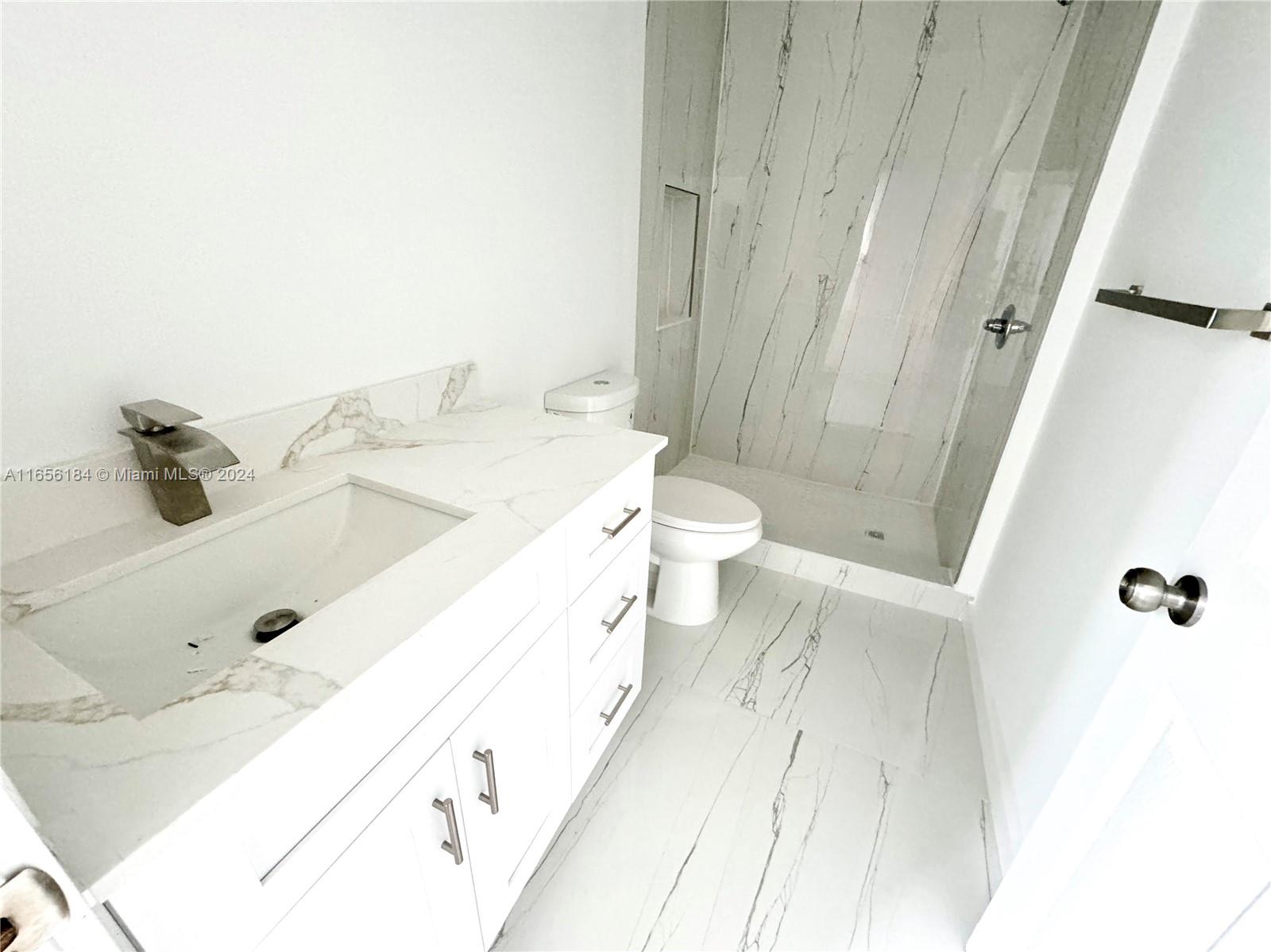 2933 Northwest 57th Street, Unit 2933 Miami, FL 33142 - Photo 9 of 14 a bathroom with a sink a toilet and shower