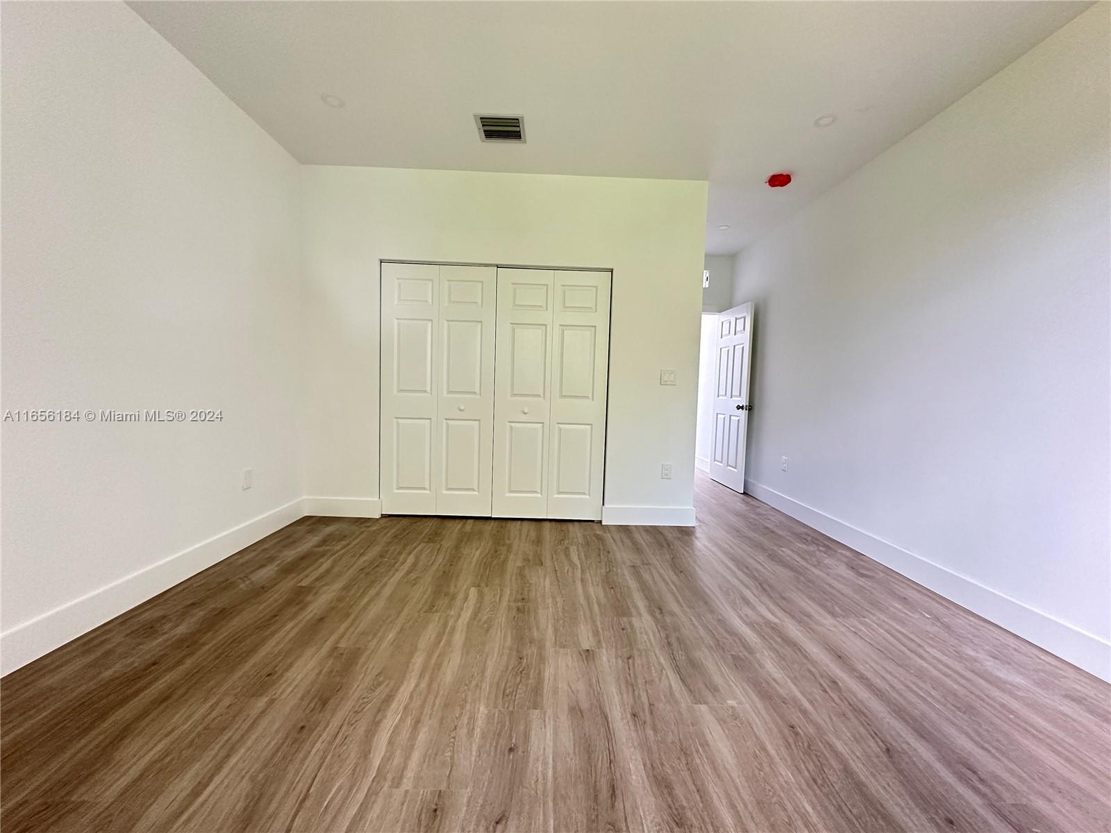 2933 Northwest 57th Street, Unit 2933 Miami, FL 33142 - Photo 10 of 14 a view of an empty room with wooden floor