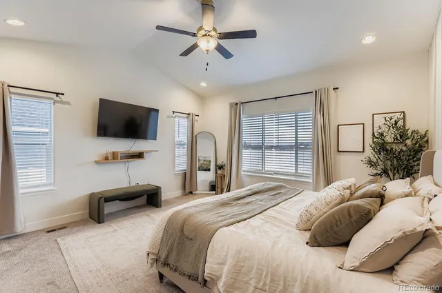a bedroom with a bed window and a flat screen tv