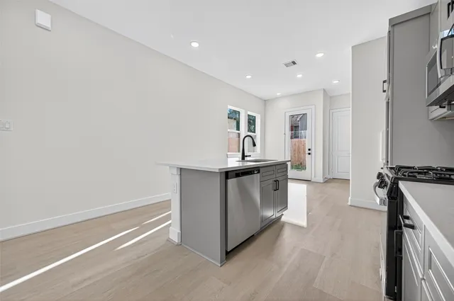 a kitchen with stainless steel appliances granite countertop a stove and a refrigerator