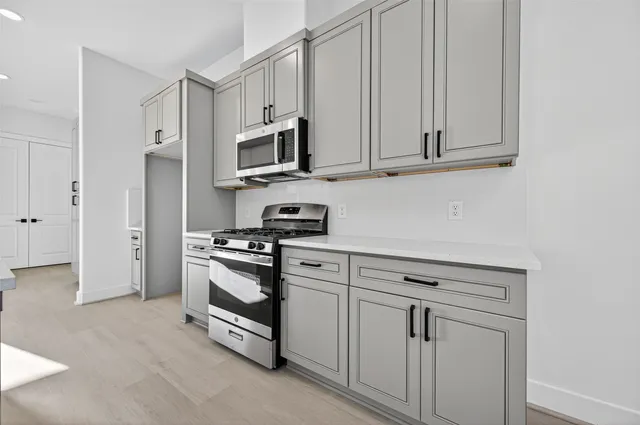 a kitchen with white cabinets and stainless steel appliances