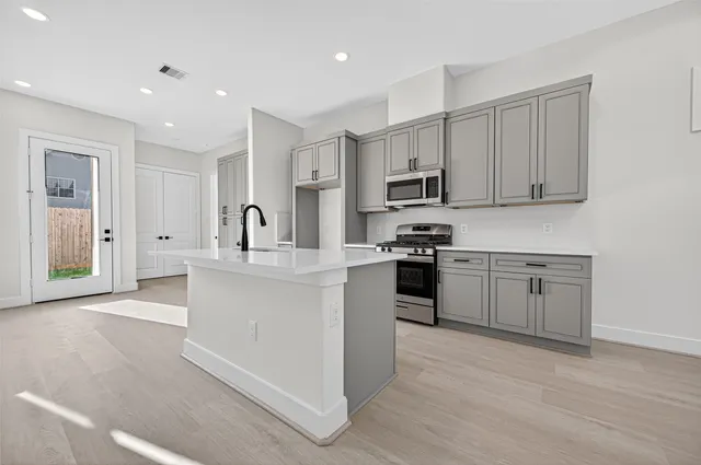 a kitchen with white cabinets and stainless steel appliances