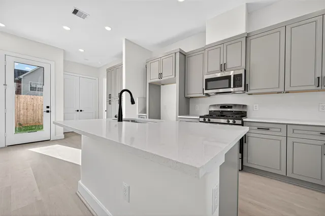 a kitchen with stainless steel appliances a sink stove and cabinets
