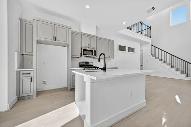 a kitchen with white cabinets and stainless steel appliances