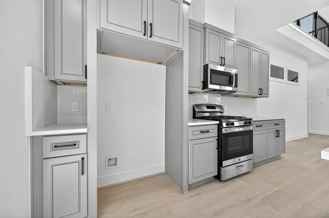 a kitchen with stainless steel appliances white cabinets and a stove