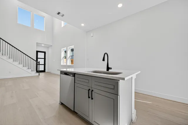 a view of a kitchen with a sink a fireplace and windows