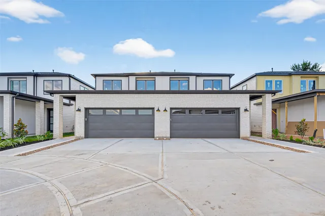 a front view of a house with yard and parking