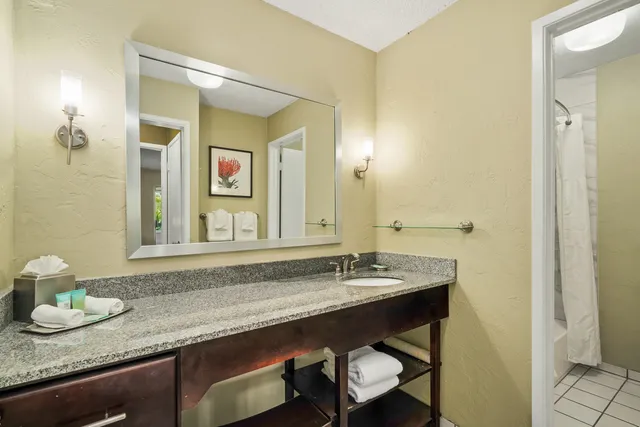 a bathroom with a granite countertop sink and a mirror