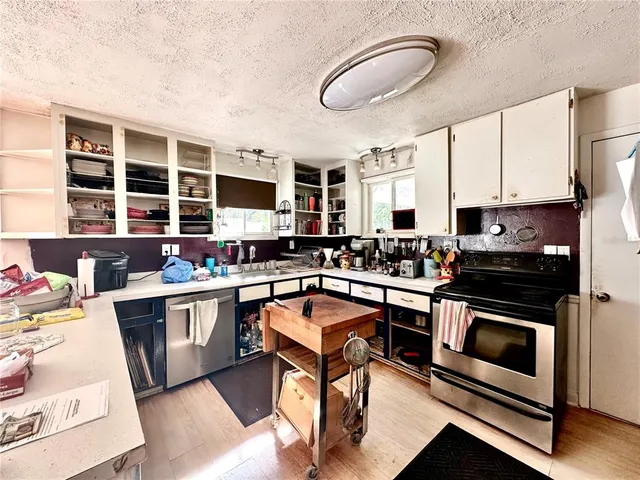a kitchen with stainless steel appliances granite countertop a stove and cabinets