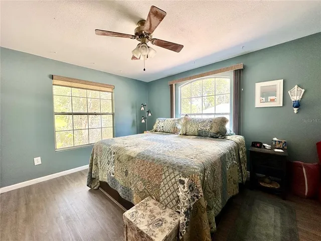 a spacious bedroom with a bed and a chandelier