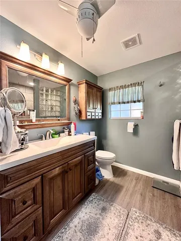 a spacious bathroom with a double vanity sink a mirror and a toilet