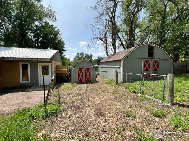 a backyard of a house with a yard and large trees