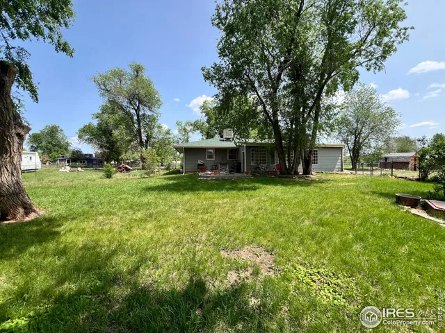 a view of a backyard with table and chairs and a yard