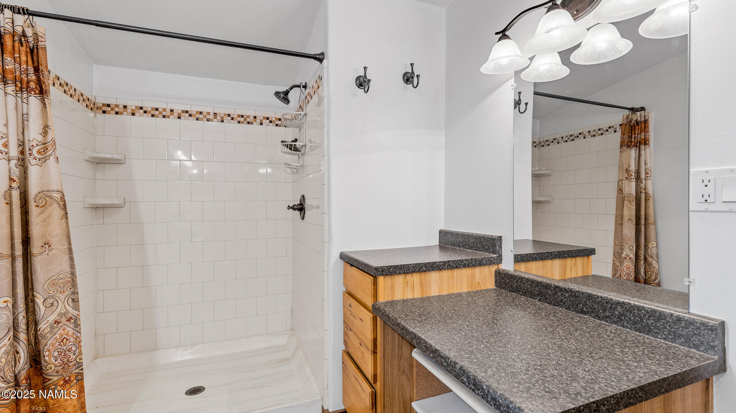 10350 Ghost Rider Trail Flagstaff, AZ 86004 - Photo 12 of 39 a bathroom with a granite countertop shower a mirror and a sink