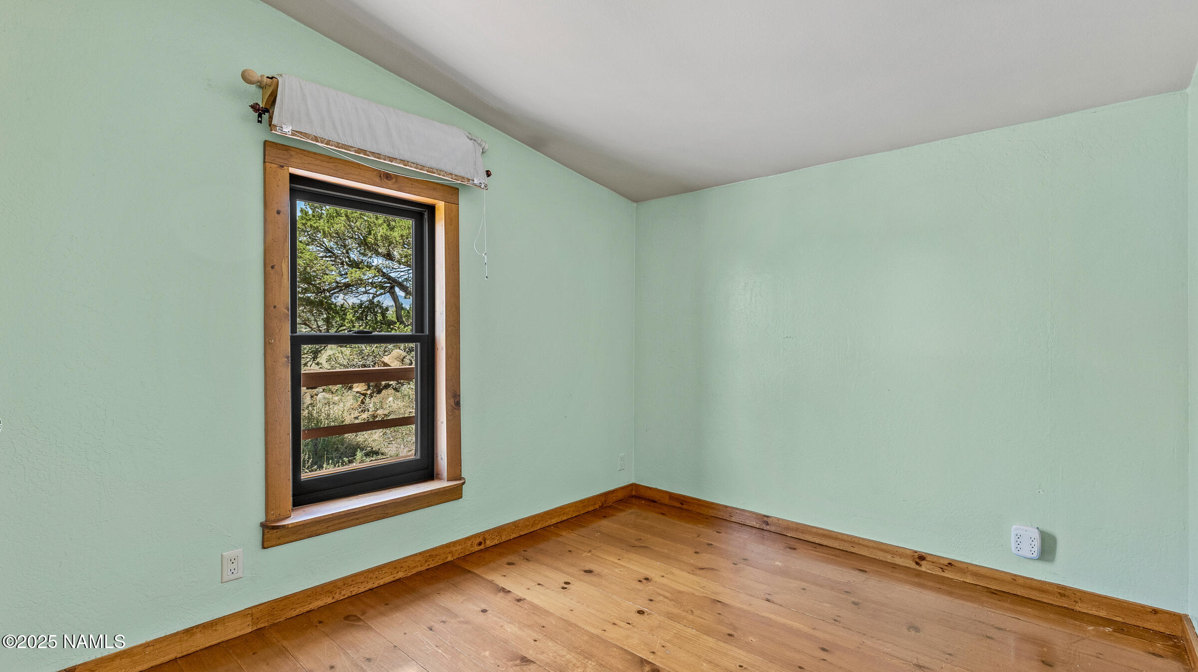 10350 Ghost Rider Trail Flagstaff, AZ 86004 - Photo 13 of 39 an empty room with window and wooden floor