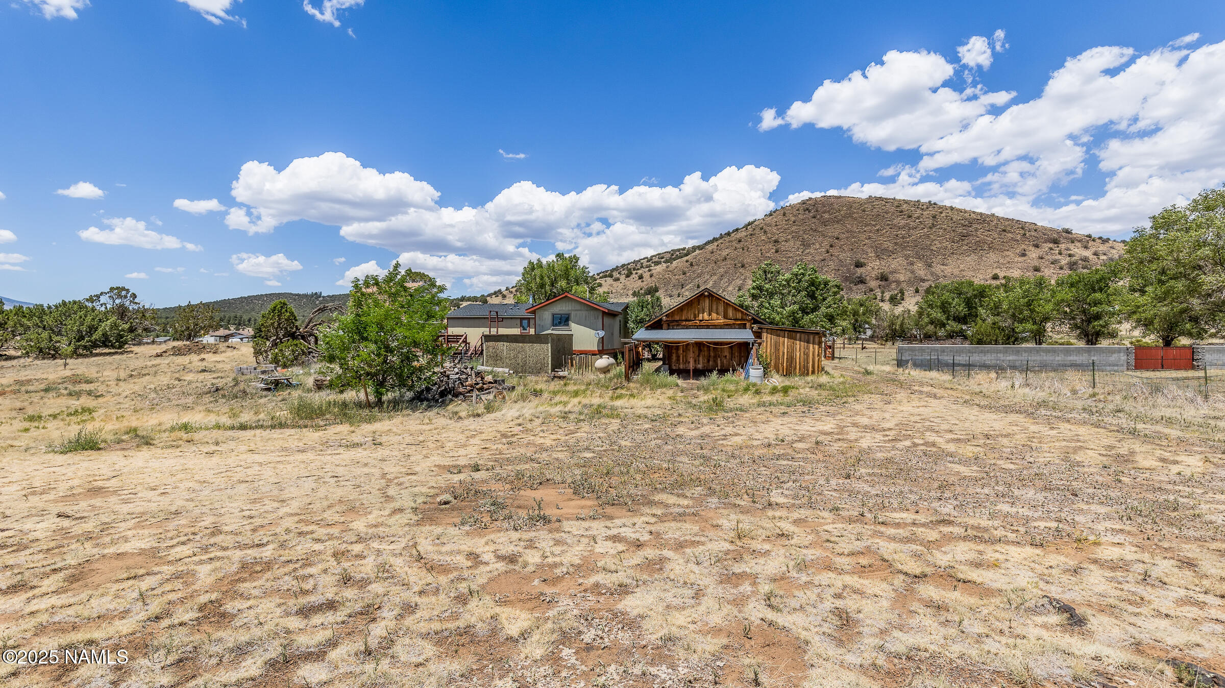 10350 Ghost Rider Trail Flagstaff, AZ 86004 - Photo 35 of 39 a front view of a house with a yard and mountain view in back