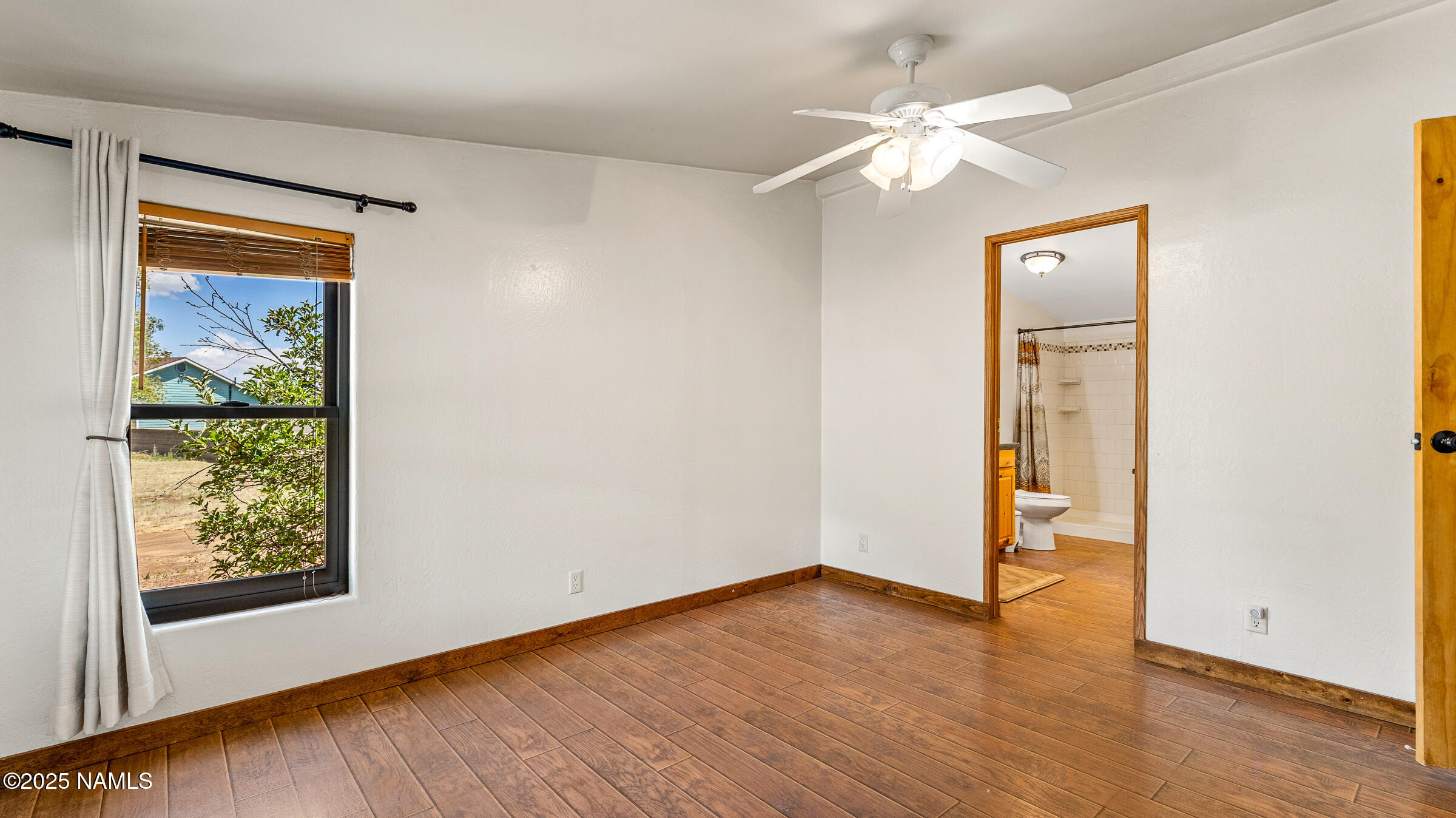 10350 Ghost Rider Trail Flagstaff, AZ 86004 - Photo 10 of 39 a view of an empty room with wooden floor and a window