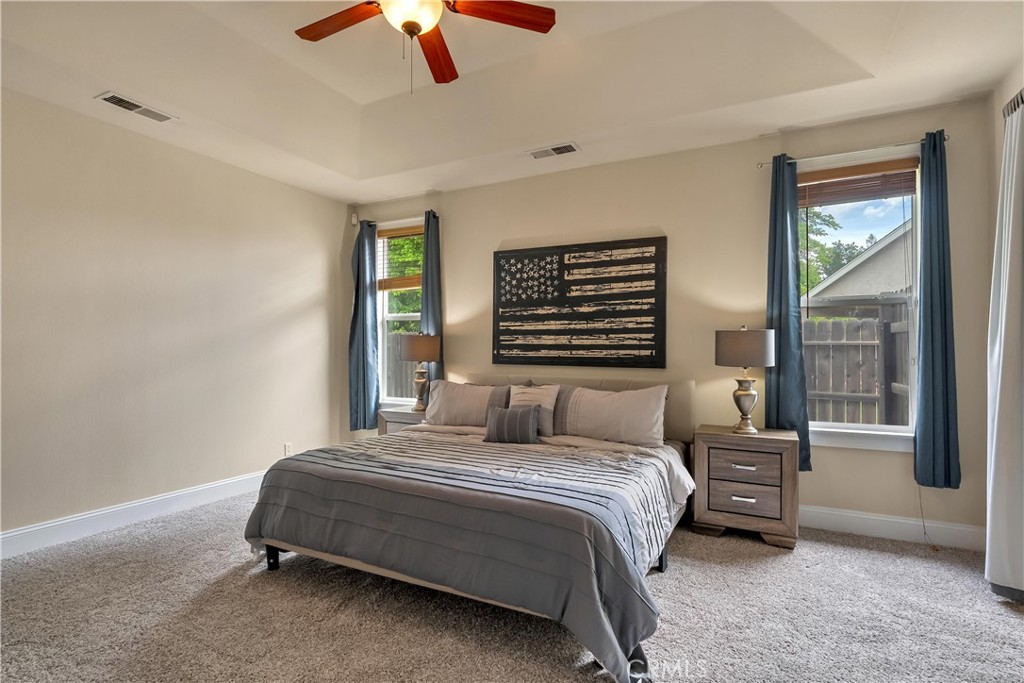 39 Redeemers Loop Chico, CA 95973 - Photo 29 of 55 a bedroom with a bed a chandelier and a window