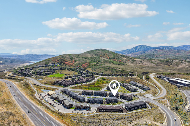 1107 West Wasatch Springs Road, Unit M3 Heber City, UT 84036 - Photo 29 of 34 Aerial perspective with surrounding mountainous terrain, multiple residential structures, and a prominent roadway