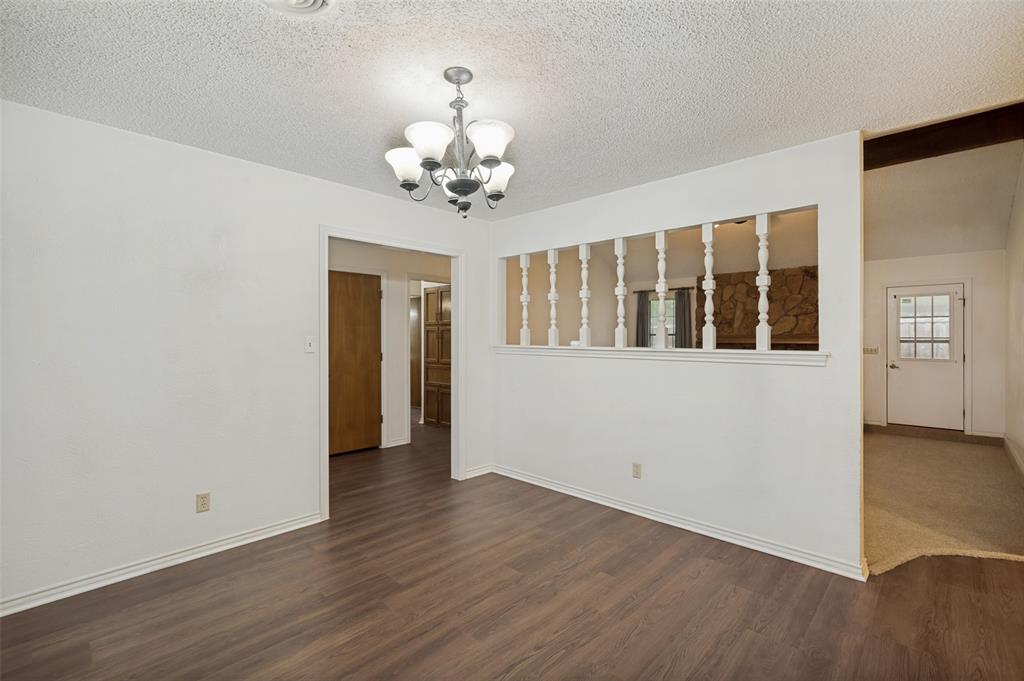 508 South Pedigo Street Pilot Point, TX 76258 - Photo 8 of 26 Spacious dining room featuring wood-finish flooring, light gray walls, and a window with gray drapes