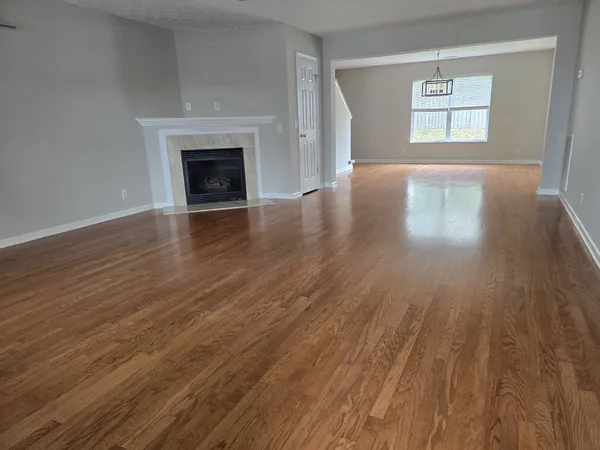 wooden floor fireplace and windows in an empty room