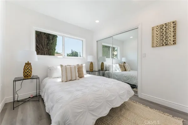 a bedroom with a bed and a painting on the wall