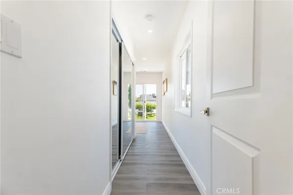 a view of a hallway with wooden floor and staircase