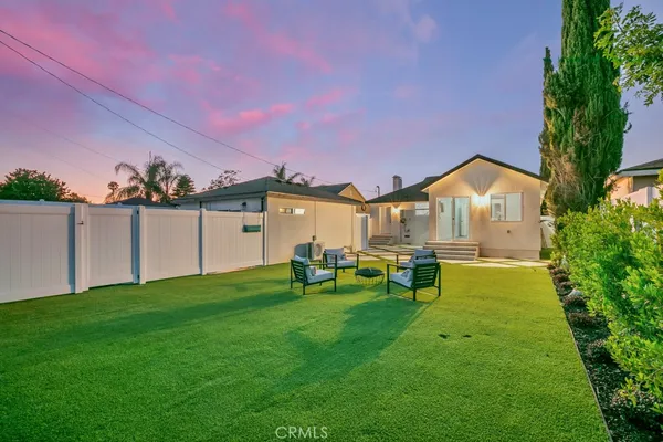 a view of a house with backyard and a tree