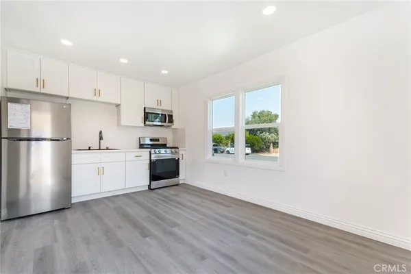 a kitchen with granite countertop white cabinets and stainless steel appliances