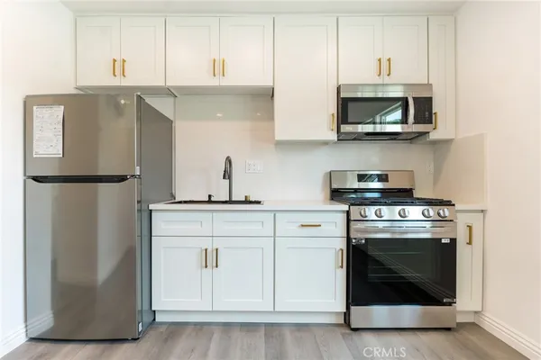a kitchen with stainless steel appliances granite countertop a stove a refrigerator and a microwave