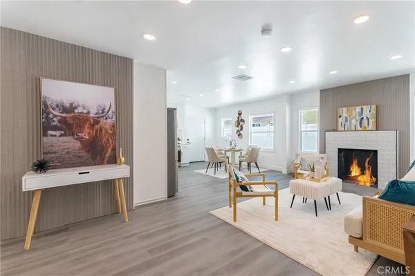 a living room with furniture a fireplace and a large window