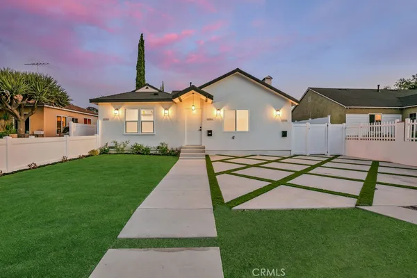 a front view of a house with a yard and outdoor seating