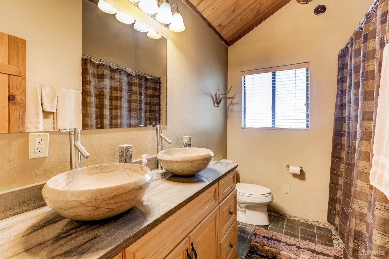 3140 Sacramento Avenue South Lake Tahoe, CA 96150 - Photo 13 of 30 a bathroom with a granite countertop sink and a mirror