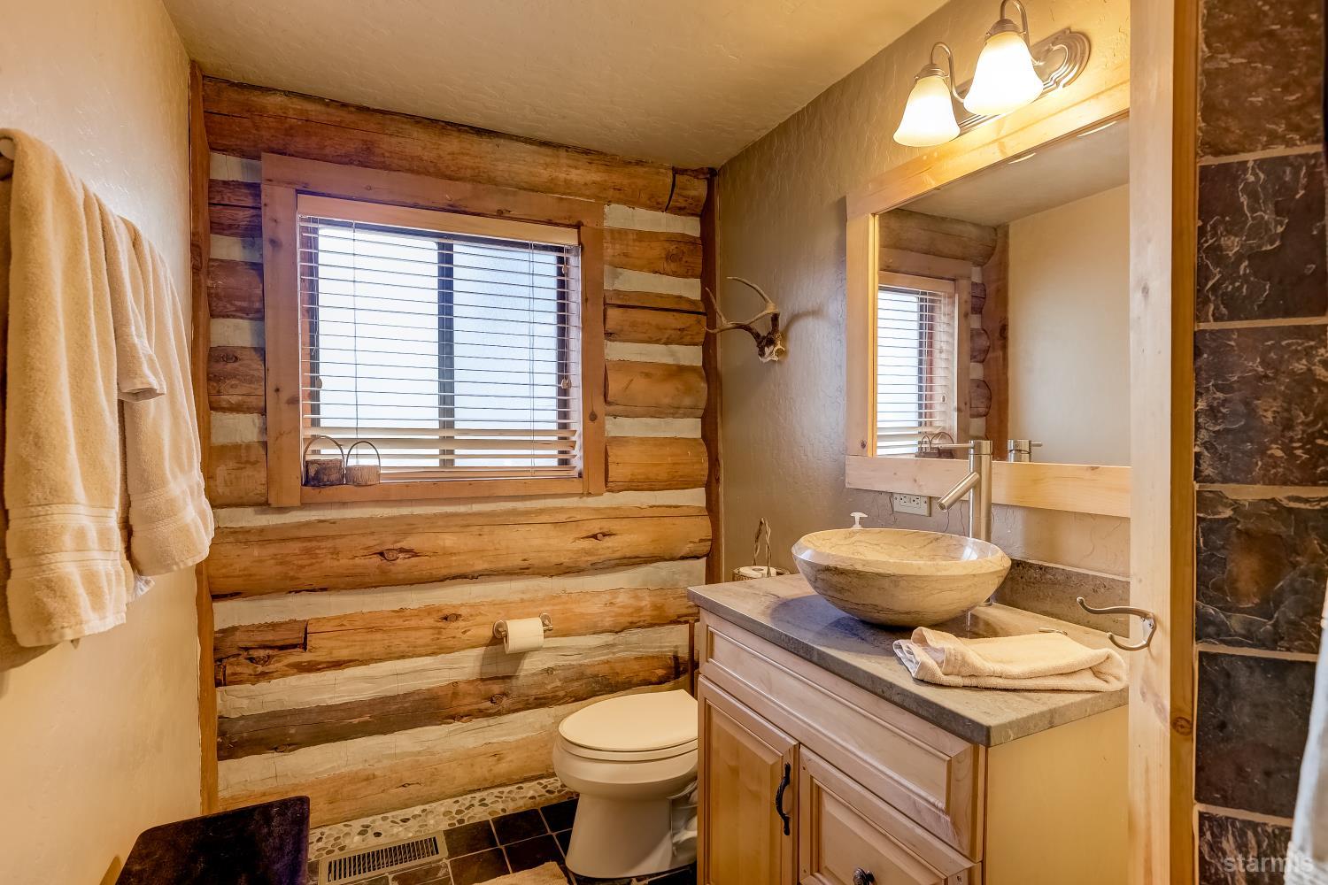 3140 Sacramento Avenue South Lake Tahoe, CA 96150 - Photo 14 of 30 a bathroom with a granite countertop toilet sink and mirror