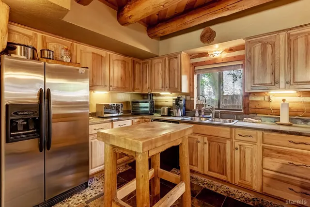 a kitchen with stainless steel appliances granite countertop a stove a sink and a refrigerator