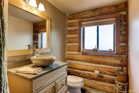 a bathroom with a granite countertop toilet a sink and a mirror