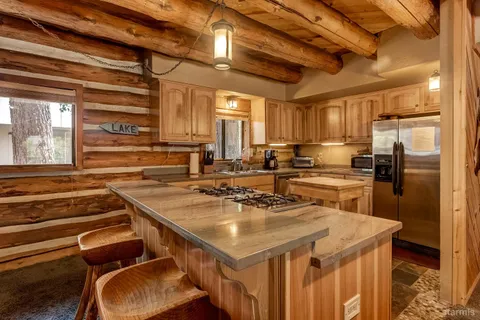 a kitchen with a sink a counter top space stainless steel appliances and cabinets